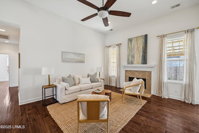 living area featuring hardwood / wood-style floors, visible vents, and ceiling fan