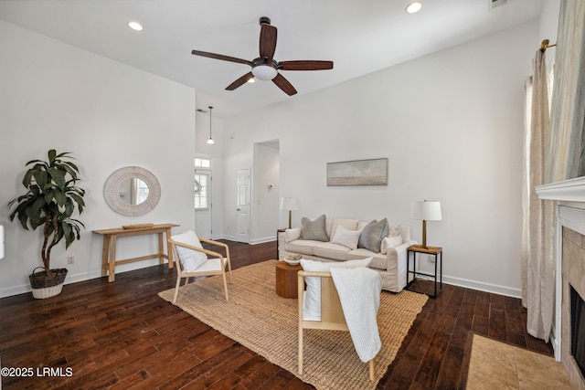 living area featuring a ceiling fan, hardwood / wood-style floors, recessed lighting, baseboards, and a tile fireplace