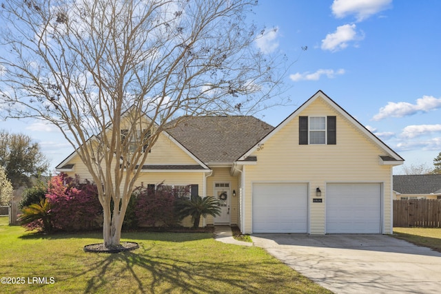 traditional home featuring a front lawn, driveway, fence, a shingled roof, and a garage