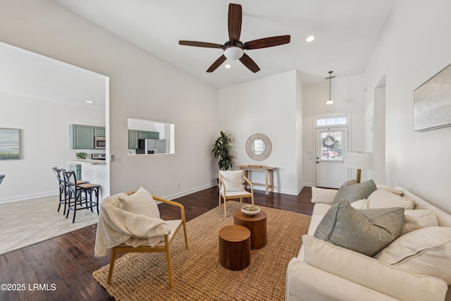 living area with recessed lighting, a ceiling fan, baseboards, and dark wood-style flooring