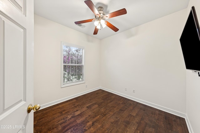 spare room featuring visible vents, baseboards, ceiling fan, and dark wood-style flooring