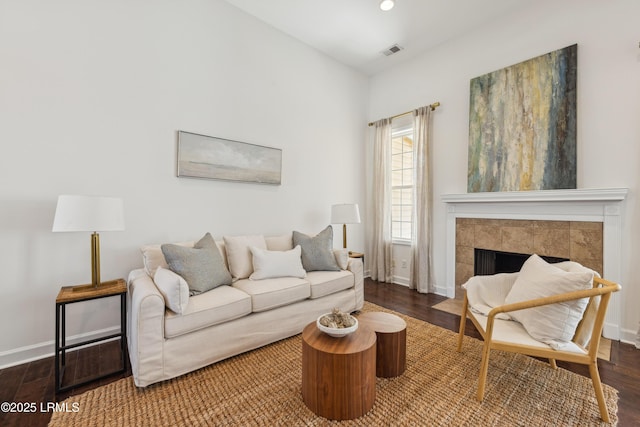 living area with wood finished floors, visible vents, and baseboards