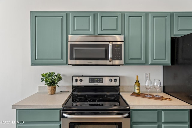 kitchen with appliances with stainless steel finishes, light countertops, and green cabinets