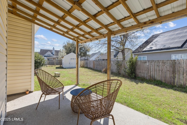 view of patio / terrace featuring an outbuilding, a fenced backyard, and a shed