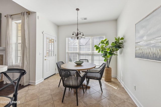 dining space with a notable chandelier, baseboards, visible vents, and light tile patterned floors