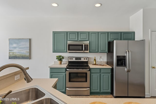 kitchen featuring green cabinetry, appliances with stainless steel finishes, a sink, and light countertops