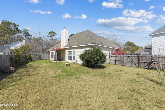 back of property featuring a lawn, a fenced backyard, and a chimney