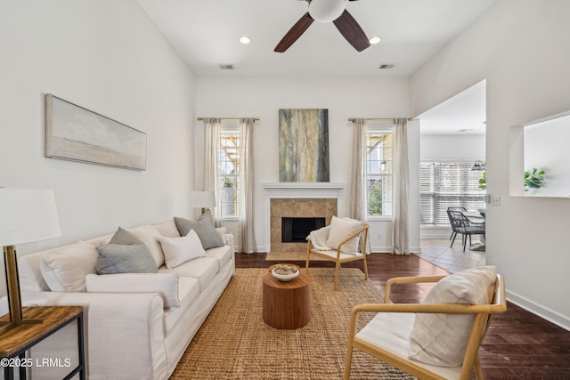 living room featuring a wealth of natural light, visible vents, wood finished floors, and ceiling fan