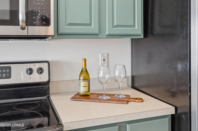 kitchen featuring light countertops, appliances with stainless steel finishes, and green cabinetry