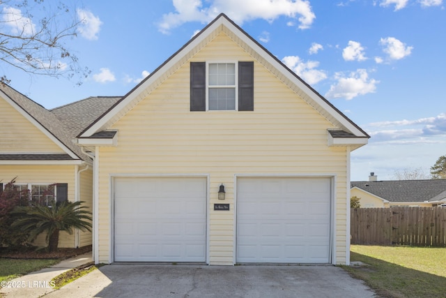 garage with fence and driveway