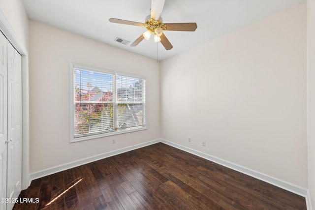 unfurnished bedroom featuring visible vents, a ceiling fan, a closet, baseboards, and dark wood-style flooring