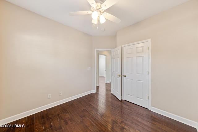 unfurnished bedroom featuring baseboards, dark wood finished floors, and a ceiling fan