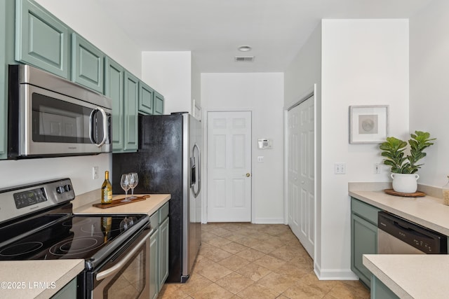 kitchen with green cabinets, light countertops, visible vents, and appliances with stainless steel finishes