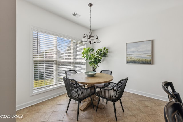 dining area featuring light tile patterned floors, visible vents, baseboards, and a chandelier