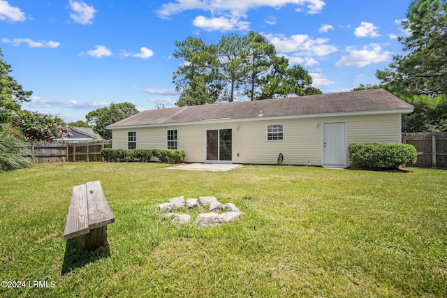 back of property featuring a patio area, fence, a lawn, and a shingled roof