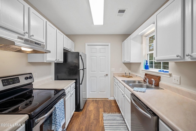 kitchen featuring visible vents, under cabinet range hood, a sink, dark wood finished floors, and stainless steel appliances