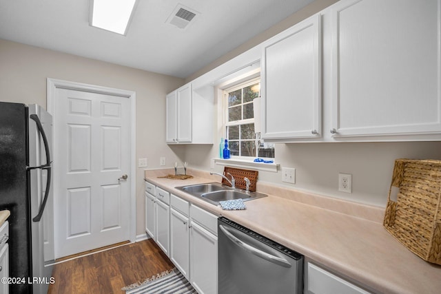 kitchen featuring visible vents, dark wood-style flooring, a sink, stainless steel appliances, and white cabinets