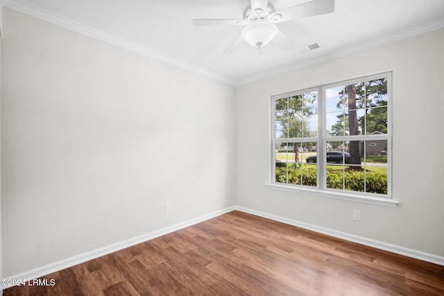 unfurnished room with visible vents, baseboards, wood finished floors, and crown molding