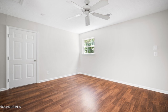 unfurnished room with a ceiling fan, visible vents, wood finished floors, and baseboards