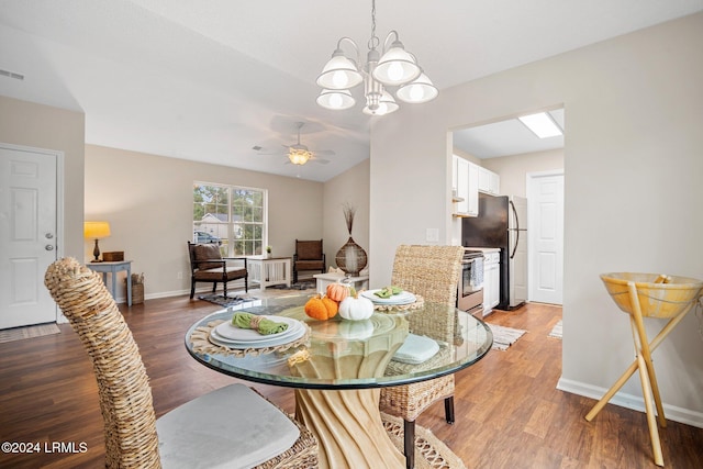 dining room featuring visible vents, baseboards, light wood-style flooring, and ceiling fan with notable chandelier