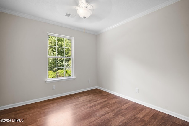 empty room featuring a ceiling fan, visible vents, baseboards, dark wood finished floors, and crown molding