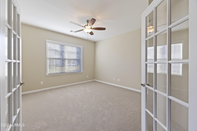 unfurnished room featuring light colored carpet, french doors, and ceiling fan