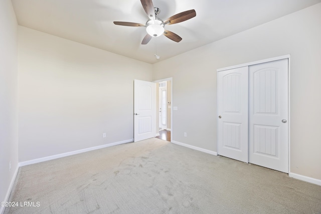 unfurnished bedroom featuring ceiling fan, light carpet, and a closet