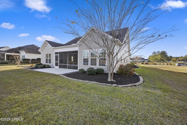 view of home's exterior with a patio area, a sunroom, and a lawn