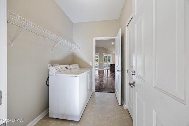 laundry area with separate washer and dryer and light tile patterned floors