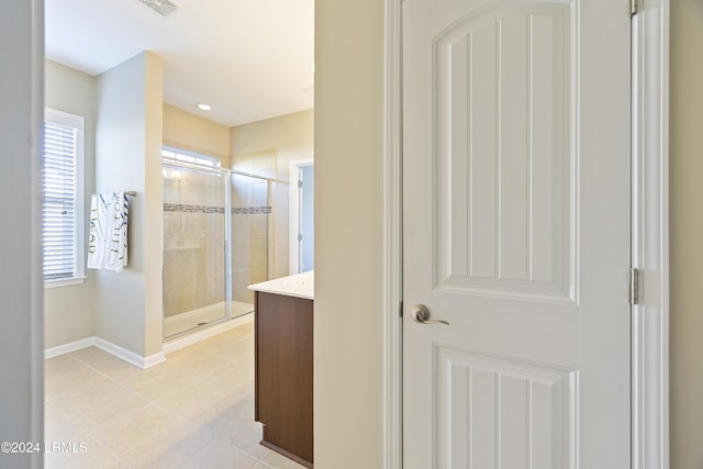 bathroom with vanity, a wealth of natural light, and a shower with shower door