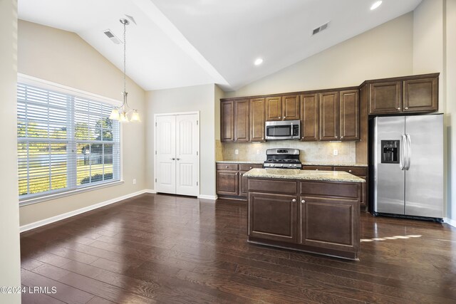 kitchen with dark brown cabinetry, a center island, pendant lighting, stainless steel appliances, and decorative backsplash