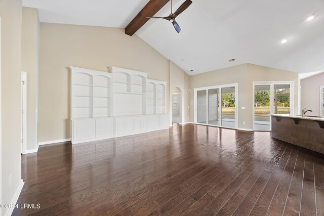 unfurnished living room with ceiling fan, dark hardwood / wood-style flooring, sink, and vaulted ceiling with beams