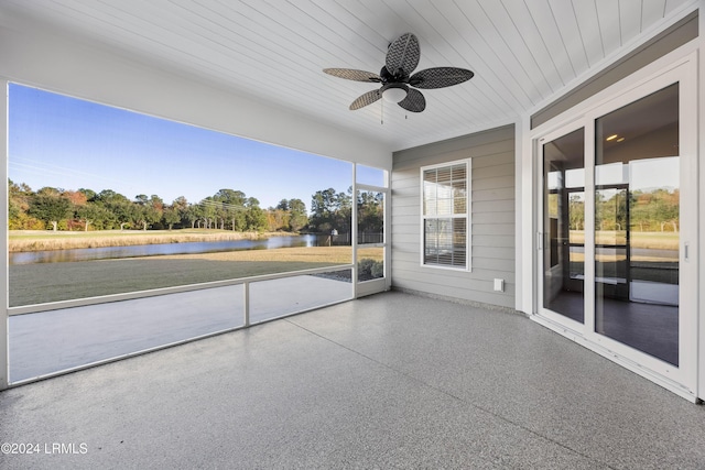 unfurnished sunroom featuring a water view and ceiling fan