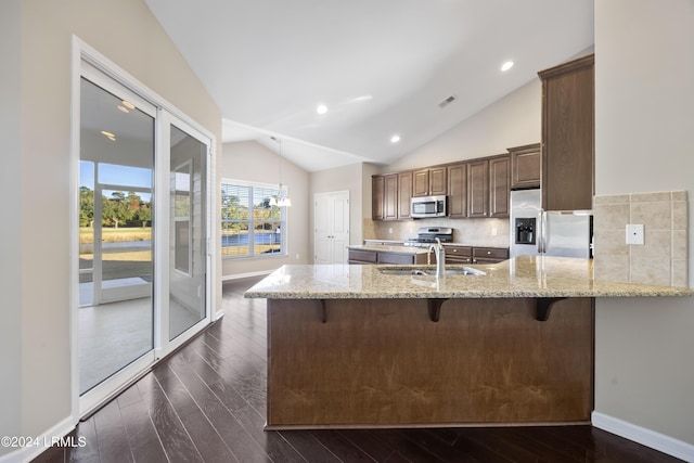 kitchen featuring tasteful backsplash, sink, a breakfast bar area, kitchen peninsula, and stainless steel appliances