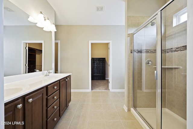 bathroom featuring tile patterned flooring, vanity, and a shower with door