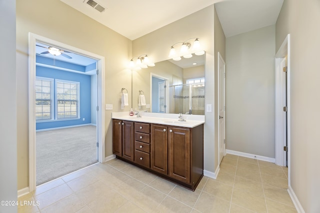 bathroom with tile patterned flooring, vanity, ceiling fan, and an enclosed shower