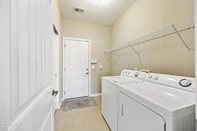 laundry area featuring washer and dryer and light tile patterned floors