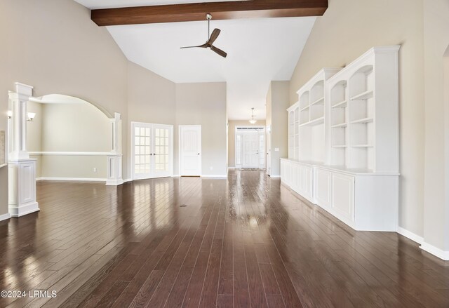 unfurnished living room with high vaulted ceiling, beamed ceiling, decorative columns, ceiling fan, and dark wood-type flooring