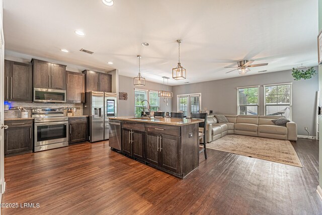 kitchen featuring a sink, stainless steel appliances, dark wood-style floors, and dark brown cabinets