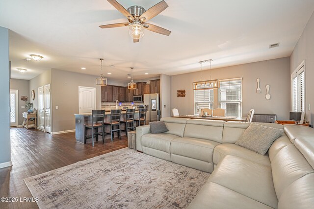 living room with baseboards, a ceiling fan, recessed lighting, and visible vents