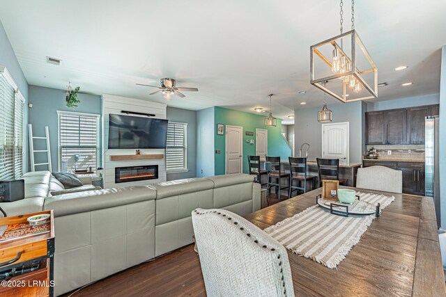 dining room featuring visible vents, dark wood finished floors, ceiling fan with notable chandelier, and a healthy amount of sunlight