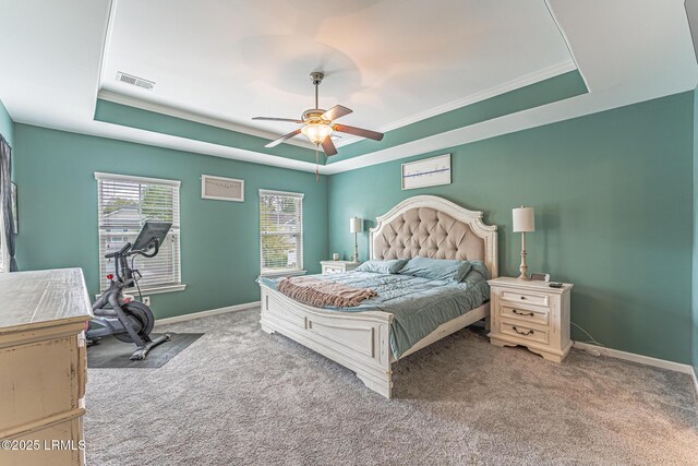 bedroom featuring carpet flooring, a tray ceiling, visible vents, and baseboards