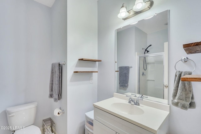 bathroom featuring vanity, toilet, and a shower with shower door