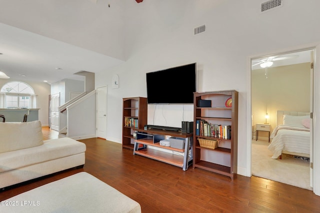 living room with dark wood-type flooring, ceiling fan, and high vaulted ceiling