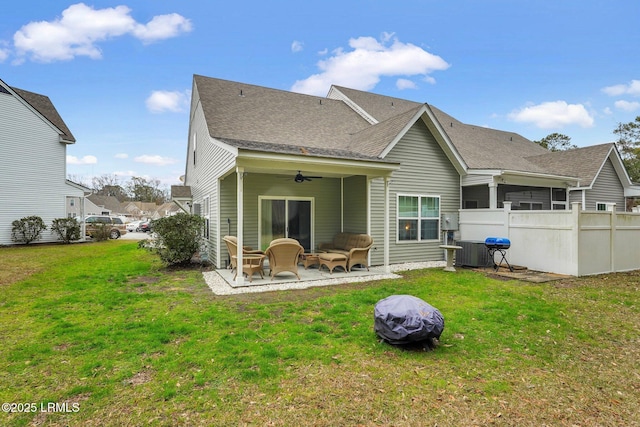 rear view of property with ceiling fan, an outdoor fire pit, a yard, and a patio