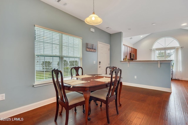 dining space featuring lofted ceiling, dark hardwood / wood-style floors, and a healthy amount of sunlight