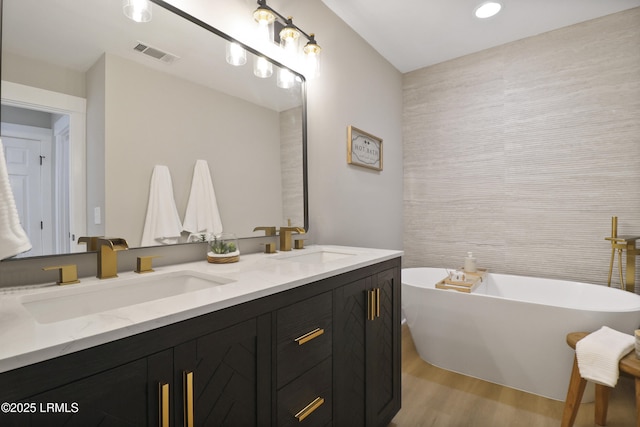 11 Lake Forest Dr Unit 3360, Hilton Head Island, SC 29928 - full bathroom featuring wood finished floors, double vanity, a freestanding tub, tile walls, and recessed lighting