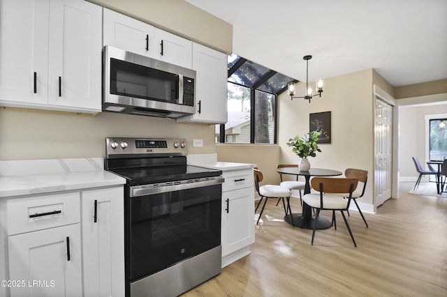 11 Lake Forest Dr Unit 3360, Hilton Head Island, SC 29928 - kitchen featuring appliances with stainless steel finishes, a chandelier, light wood-style flooring, white cabinets, and light stone countertops