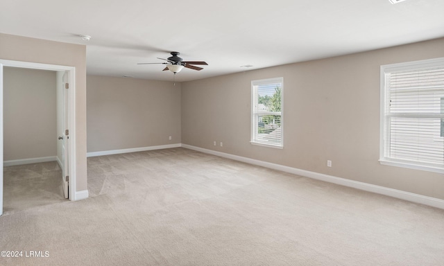 empty room featuring ceiling fan and light colored carpet