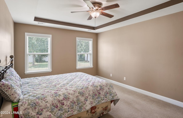 bedroom featuring carpet flooring, ceiling fan, and a tray ceiling